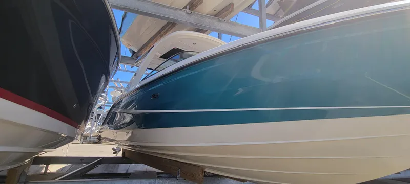  Yacht Photos Pics 2021 Sea Ray SLX 310 Outboard boat in storage, showcasing sleek blue and white hull design.