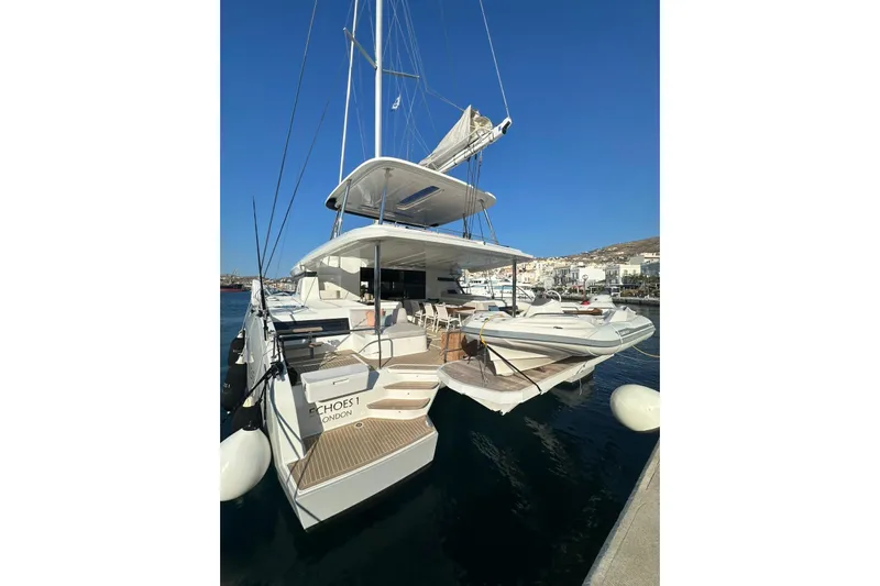 Echoes 1 Yacht Photos Pics 2023 Lagoon 55 yacht docked at a marina under clear blue skies.