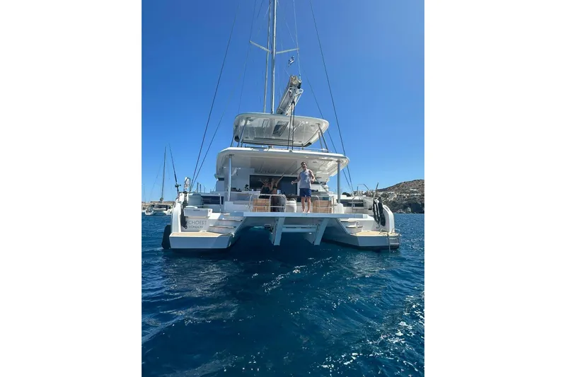 Echoes 1 Yacht Photos Pics 2023 Lagoon 55 catamaran on clear blue water, sunny day, people on deck.