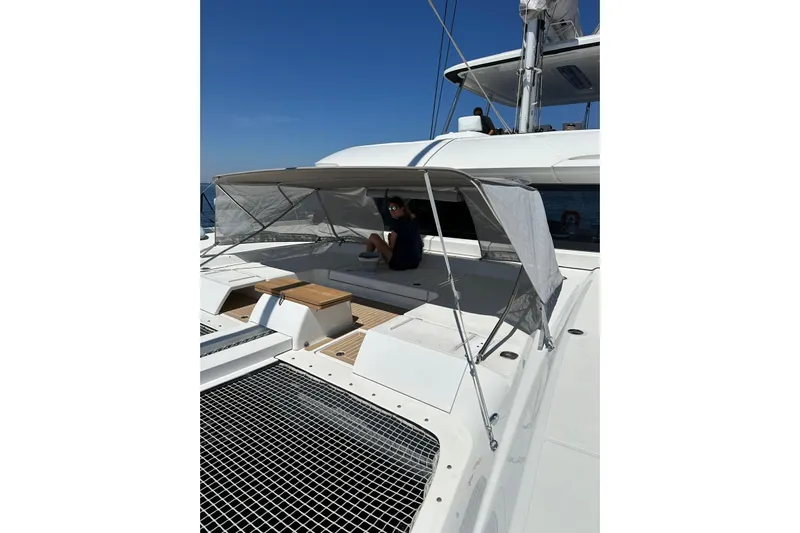 Echoes 1 Yacht Photos Pics 2023 Lagoon 55 yacht with shaded seating area on deck, under clear blue sky.