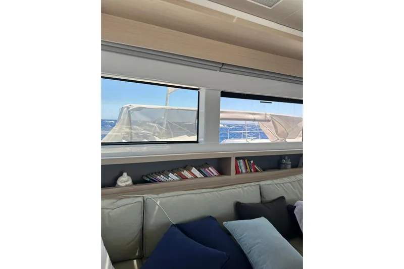 Echoes 1 Yacht Photos Pics Interior of 2023 Lagoon 55 yacht with books and ocean view through windows.