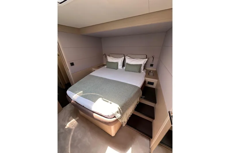 Echoes 1 Yacht Photos Pics Luxurious cabin interior of 2023 Lagoon 55 yacht with cozy bed and modern design.