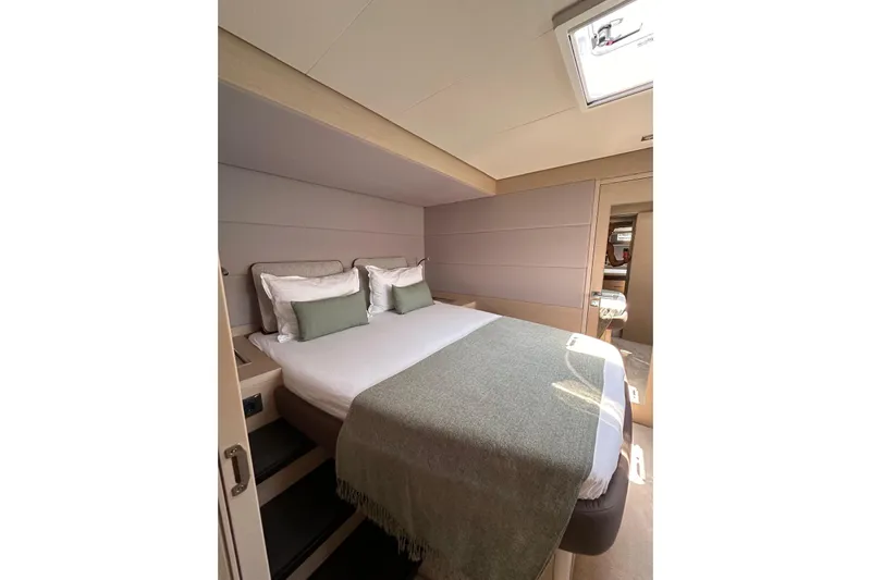 Echoes 1 Yacht Photos Pics Luxurious bedroom interior of 2023 Lagoon 55 yacht, featuring elegant bedding and modern design.