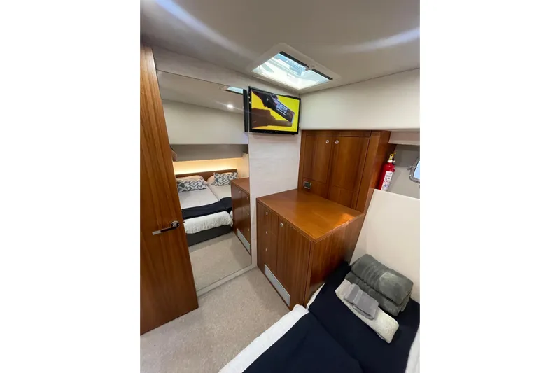 True North Yacht Photos Pics 2020 Maritimo M59 yacht interior with wood cabinetry, bed, and TV.