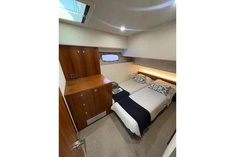 True North Yacht Photos Pics 2020 Maritimo M59 yacht cabin with twin beds, wooden cabinetry, and modern decor.