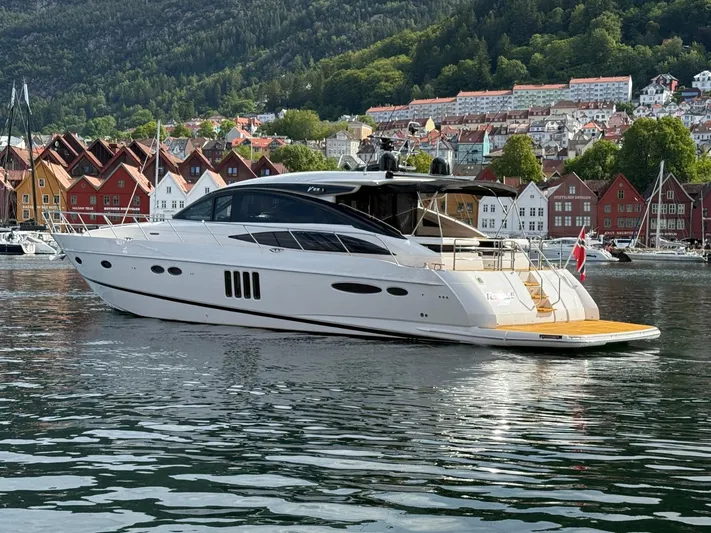  Yacht Photos Pics 2009 Princess V65 yacht docked in scenic harbor with colorful buildings and lush hills.