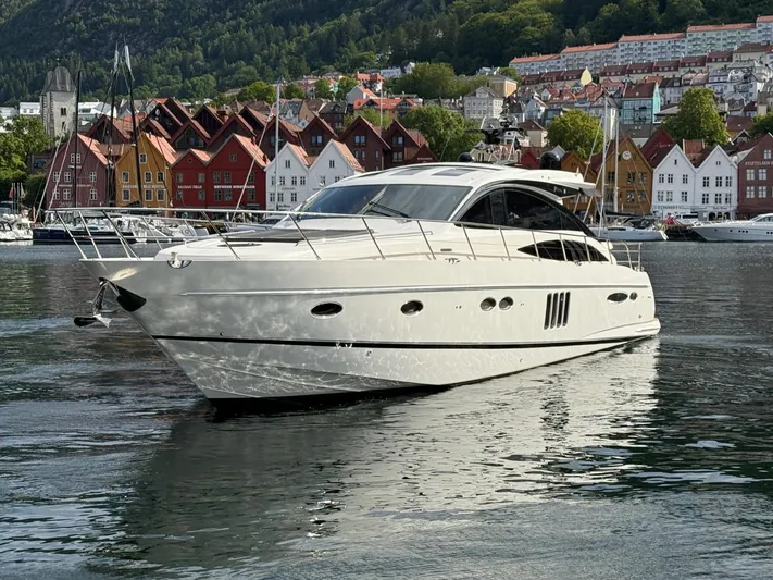  Yacht Photos Pics Luxurious 2009 Princess V65 yacht docked in scenic harbor with colorful buildings.