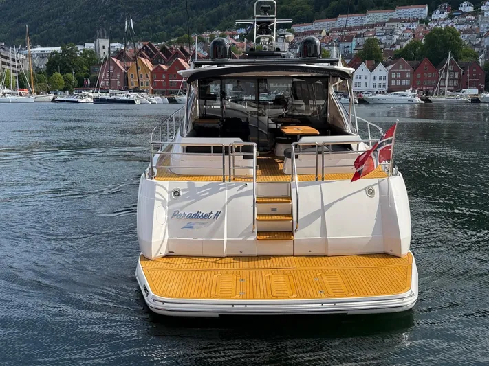 Yacht Photos Pics 2009 Princess V65 yacht docked in scenic harbor with colorful buildings in background.