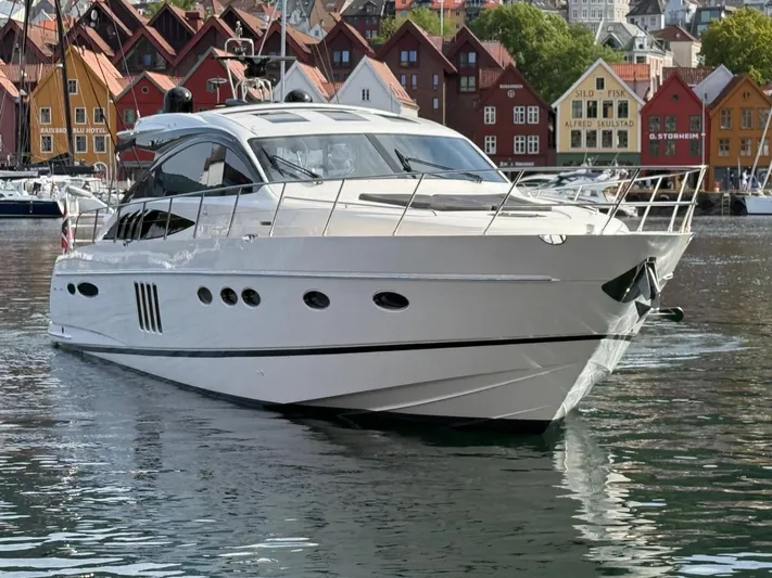  Yacht Photos Pics Luxury 2009 Princess V65 yacht docked in scenic harbor with colorful buildings.