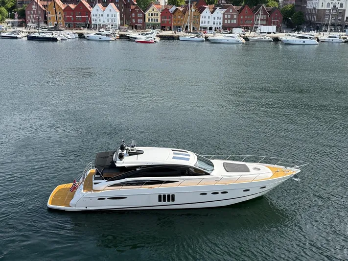  Yacht Photos Pics Luxury 2009 Princess V65 yacht cruising near colorful waterfront buildings.