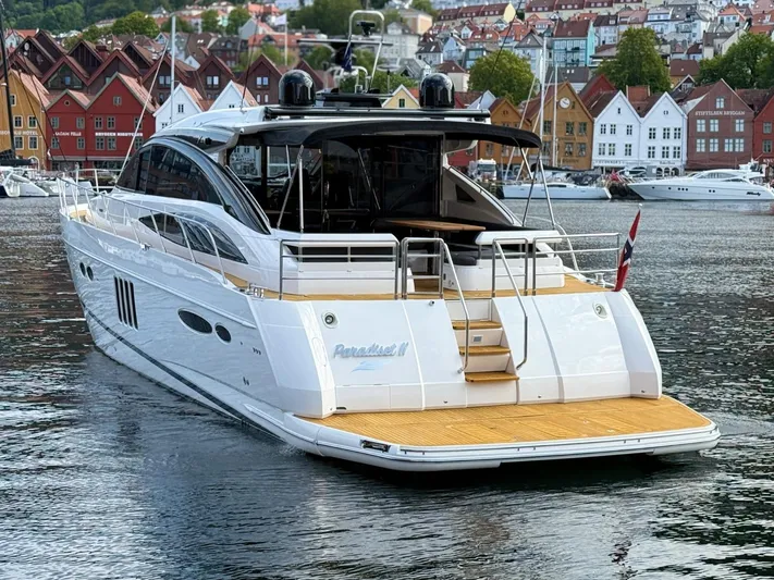  Yacht Photos Pics Luxury 2009 Princess V65 yacht docked in scenic harbor with colorful buildings.