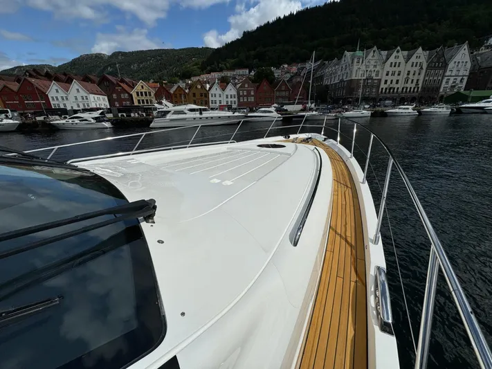  Yacht Photos Pics 2009 Princess V65 yacht docked in scenic harbor with colorful buildings and mountains.