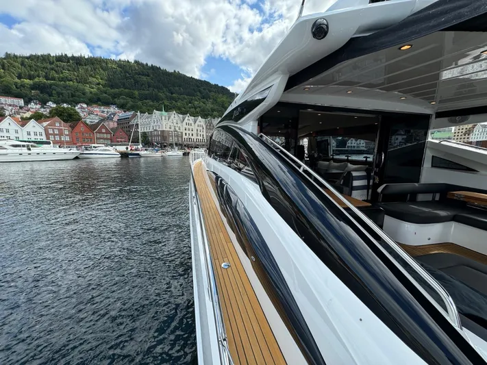  Yacht Photos Pics Luxurious 2009 Princess V65 yacht docked in scenic harbor with colorful buildings.