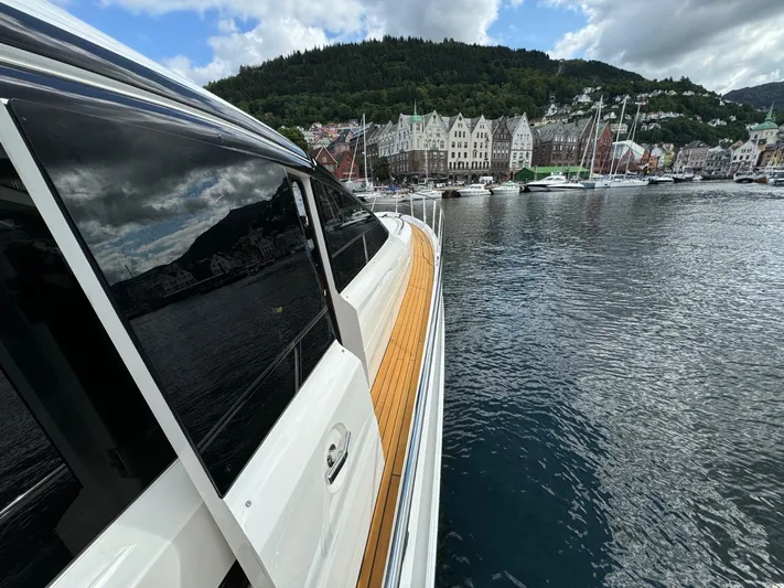  Yacht Photos Pics 2009 Princess V65 yacht docked in scenic harbor with colorful buildings and lush hills.