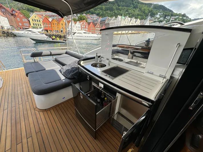  Yacht Photos Pics Luxurious 2009 Princess V65 yacht with sleek deck, kitchenette, and scenic waterfront view.
