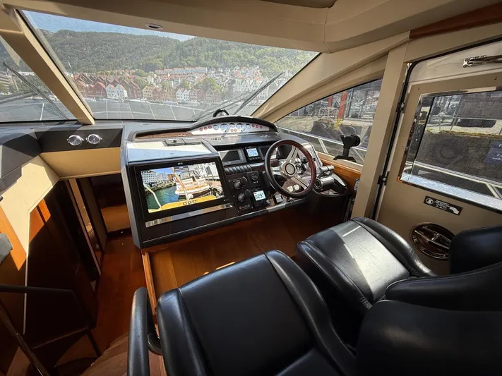  Yacht Photos Pics Interior of 2009 Princess V65 yacht cockpit with navigation controls and leather seating.