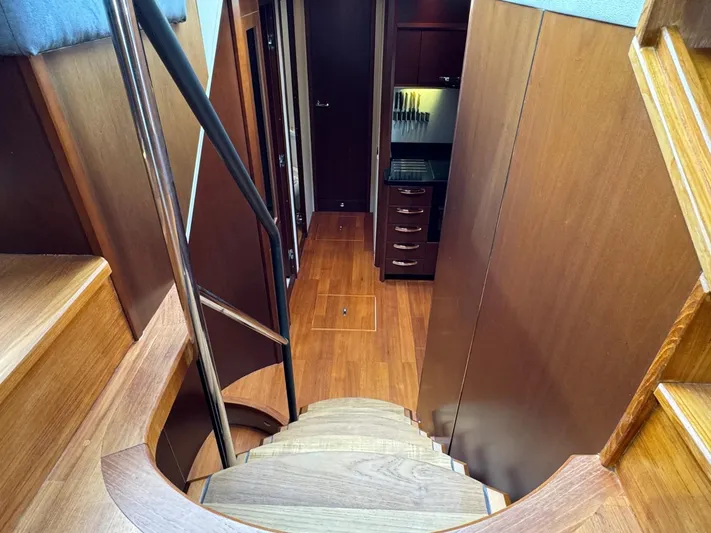  Yacht Photos Pics Staircase leading to the interior of a 2009 Princess V65 yacht, featuring wooden finishes.