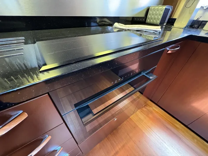  Yacht Photos Pics Modern kitchen with sleek black countertop and built-in oven on Princess V65 yacht.