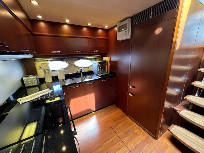  Yacht Photos Pics Luxurious 2009 Princess V65 yacht kitchen with wood cabinetry and modern appliances.
