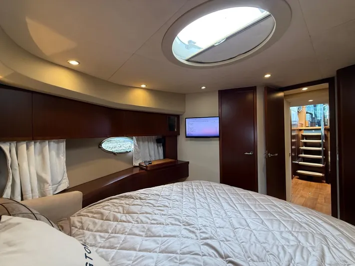  Yacht Photos Pics Luxurious interior of 2009 Princess V65 yacht with elegant wood finishes and cozy bedding.