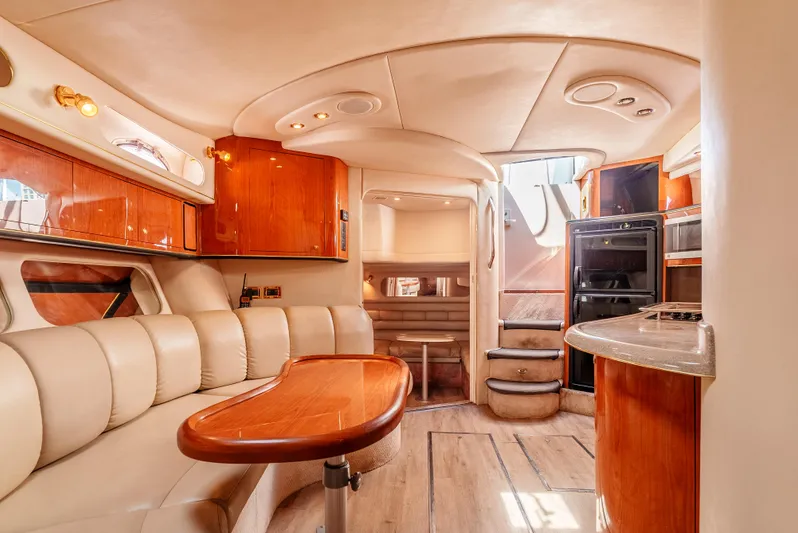 "carried Aweigh" Yacht Photos Pics Luxurious interior of 1999 Sea Ray 400 Sundancer yacht with leather seating and wooden cabinetry.