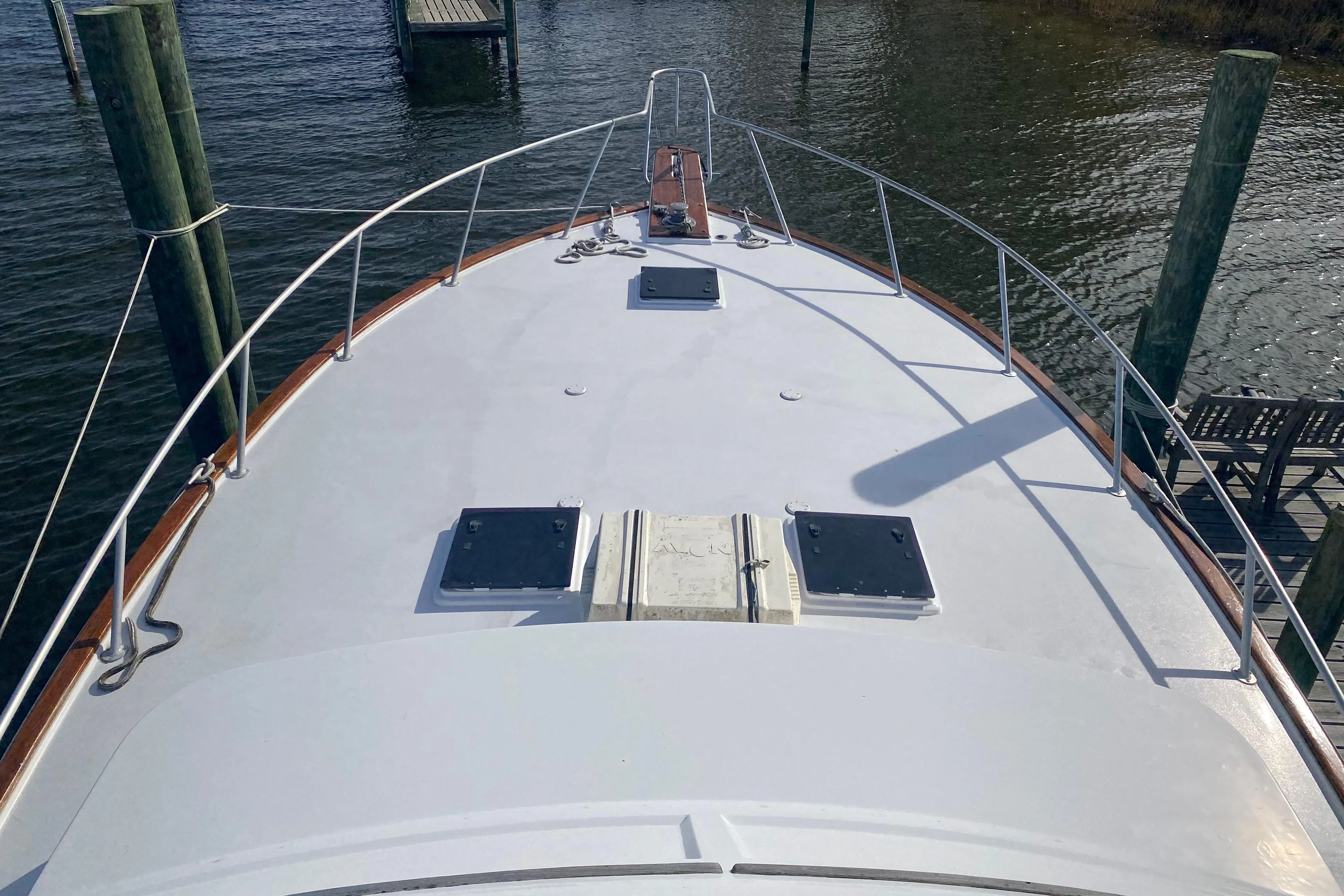 1986 Post 46 yacht deck with hatches, docked by wooden posts.