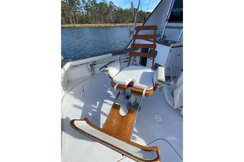 Second Chance Yacht Photos Pics Fishing chair on 1986 Post 46 yacht, docked by a serene waterway.