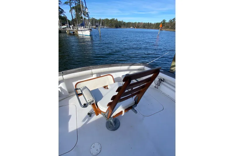 Second Chance Yacht Photos Pics Fishing chair on 1986 Post 46 boat overlooking serene marina waters.