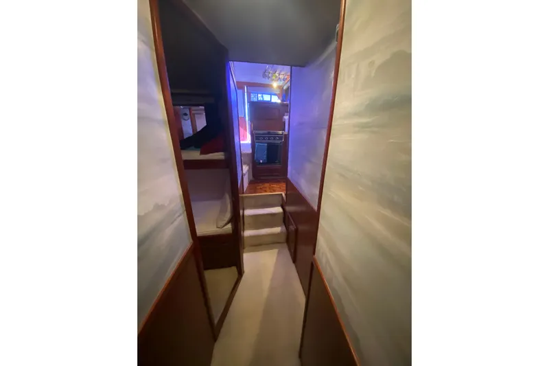 Second Chance Yacht Photos Pics Narrow hallway inside 1986 Post 46 yacht, featuring bunk beds and a small staircase.