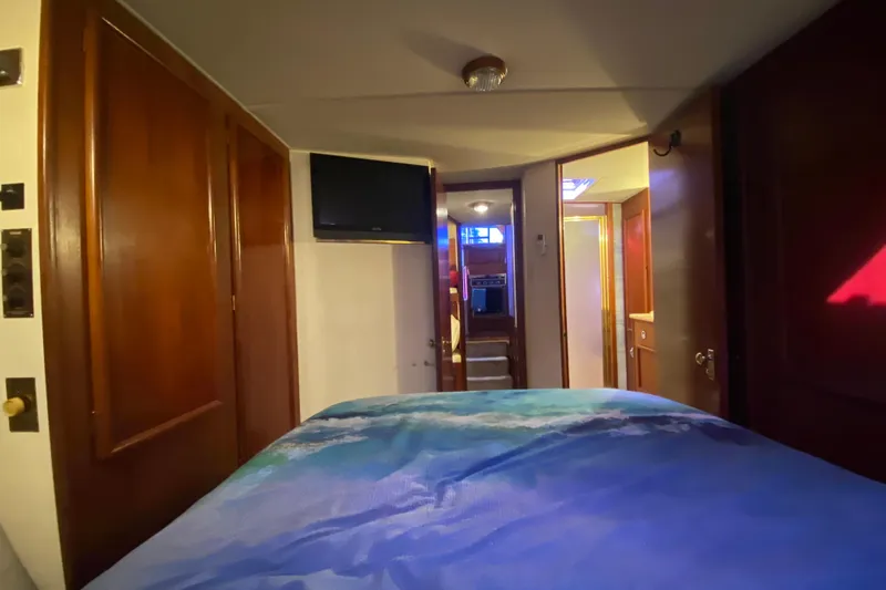 Second Chance Yacht Photos Pics Interior of 1986 Post 46 yacht bedroom with wooden doors and mounted TV.