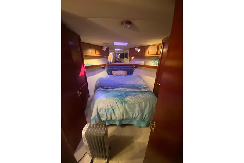 Second Chance Yacht Photos Pics Cozy bedroom interior in 1986 Post 46 yacht with blue bedding and wooden cabinets.