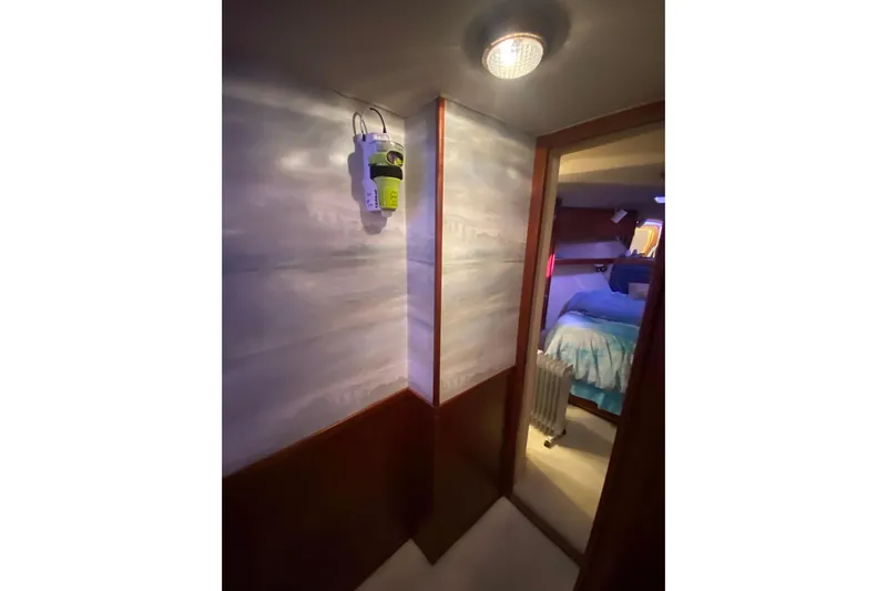 Second Chance Yacht Photos Pics Interior of a 1986 Post 46 yacht, featuring a cozy bedroom and hallway lighting.