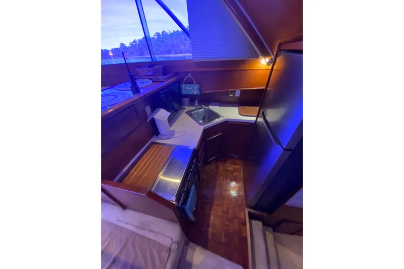 Second Chance Yacht Photos Pics Compact kitchen area in a 1986 Post 46 boat, featuring modern appliances and wood finishes.