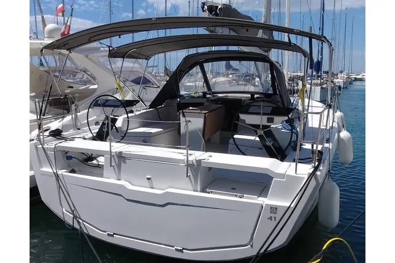  Yacht Photos Pics 2025 Dufour 41 yacht docked at marina, featuring dual steering wheels and spacious cockpit.
