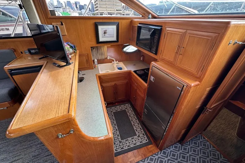 Rover Yacht Photos Pics Luxurious 1993 Ocean Alexander 460 yacht interior with kitchen, TV, and wooden cabinetry.
