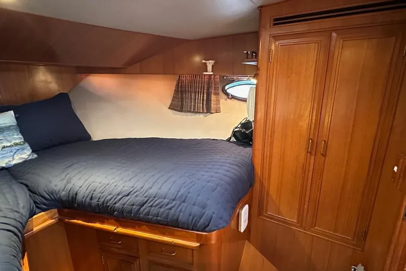 Rover Yacht Photos Pics Cozy cabin interior of 1993 Ocean Alexander 460 yacht with wooden furnishings and blue bedding.