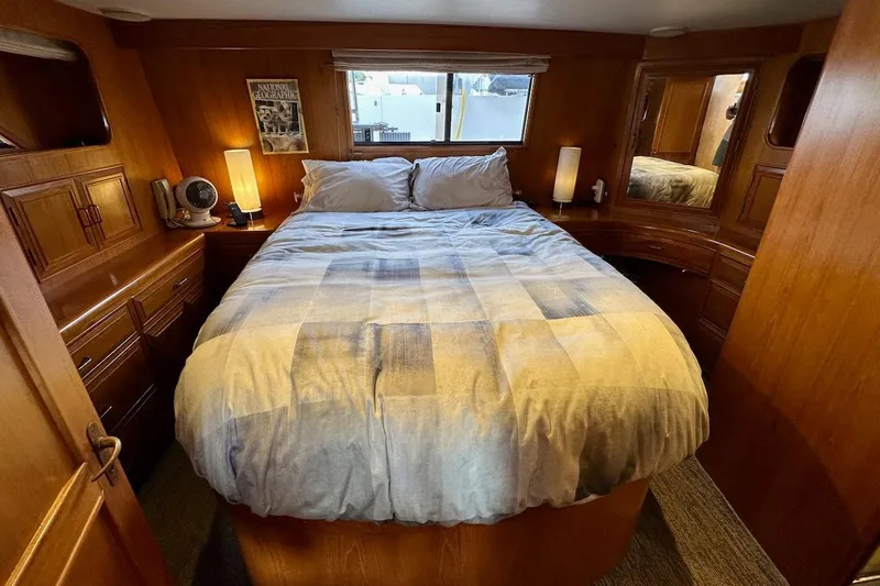 Rover Yacht Photos Pics Cozy bedroom in 1993 Ocean Alexander 460 yacht with wood paneling and soft lighting.