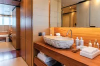 Luxurious bathroom with stone sink, wooden accents, and modern fixtures on an ISA Custom 2012 model.