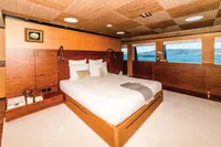 Luxurious yacht bedroom with ocean view, featuring elegant wood paneling and modern decor.
