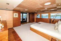 Luxurious yacht bedroom with wooden decor, large windows, and scenic ocean view. ISA Custom 2012 model.