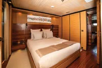 Luxurious yacht bedroom with wooden decor, cozy bedding, and modern lighting, ISA Custom 2012 model.