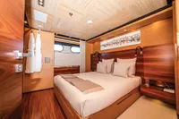 Luxurious yacht bedroom with wooden decor, double bed, and modern lighting, ISA Custom 2012 model.