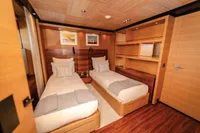 Luxurious twin bedroom on 2012 ISA Custom yacht with wooden decor and modern furnishings.