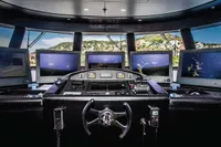 Luxurious yacht cockpit with multiple screens, ISA Custom 2012 model, overlooking scenic coastline.