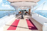 Luxurious 2012 ISA Custom yacht deck with gym equipment and yoga mats, overlooking serene ocean views.
