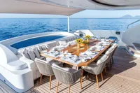 Luxurious yacht dining area with elegant table setting, ocean view, and comfortable seating.