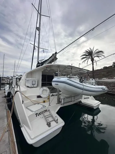 Seascape Yacht Photos Pics 2012 Leopard 39 catamaran docked, featuring a dinghy and palm tree backdrop.