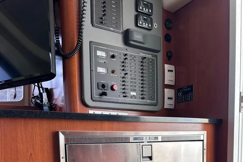 Seascape Yacht Photos Pics Control panel inside a 2012 Leopard 39 yacht, featuring electrical switches and wooden cabinetry.