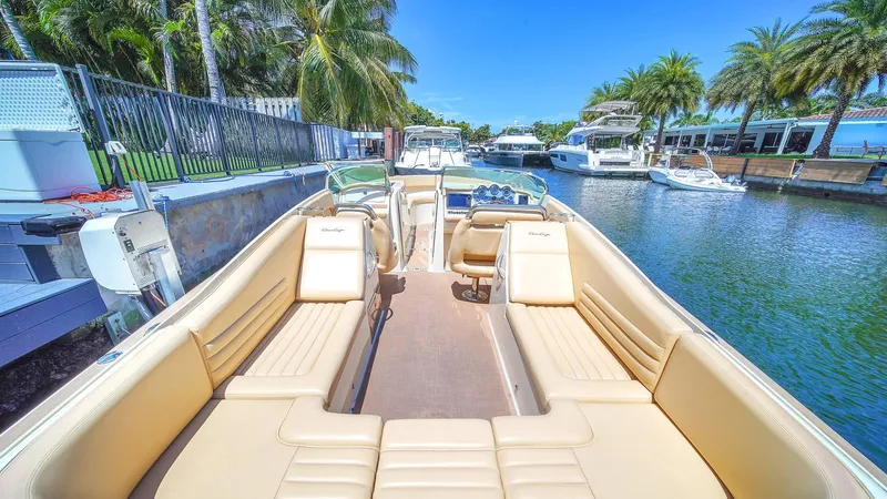 Levi Yacht Photos Pics 2013 Chris-Craft Launch 32 boat with tan seating, docked near palm trees and waterway.