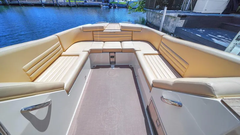 Levi Yacht Photos Pics 2013 Chris-Craft Launch 32 boat interior with beige seating, docked by the water.